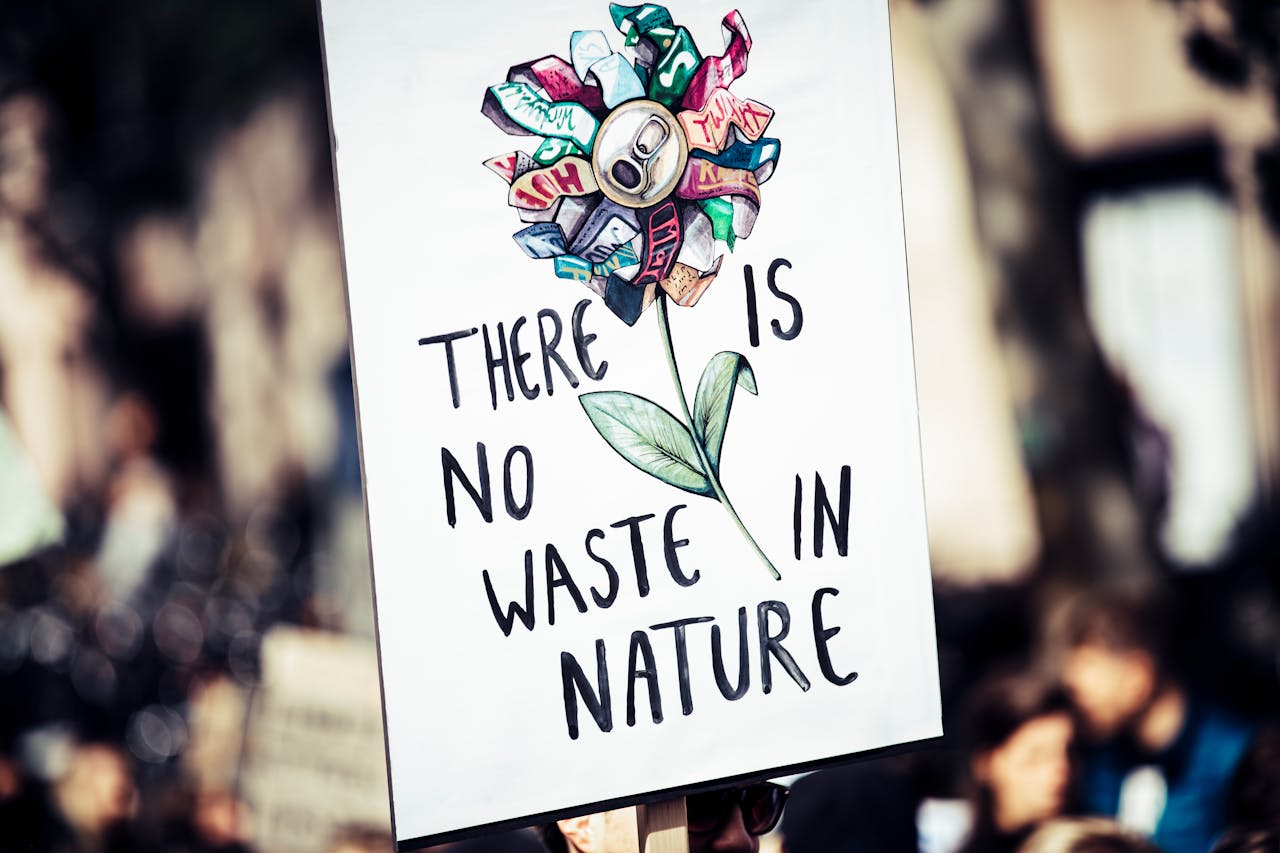 Protest sign featuring a flower made from recycled materials promoting environmental conservation.