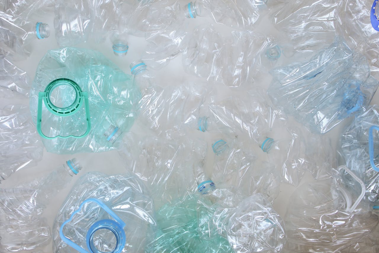 Top-view of crushed plastic bottles prepared for recycling, promoting sustainability.